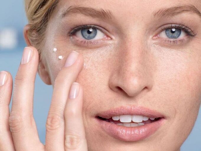 applying skin rejuvenating cream around the eyes